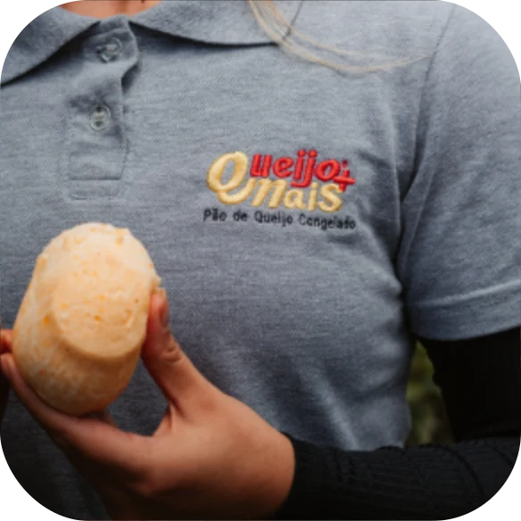 Colaboradora Queijo Mais apresentando um pão de queijo